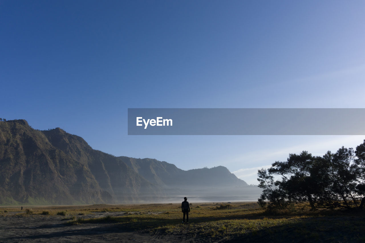 Man standing on mountain against clear sky mount bromo