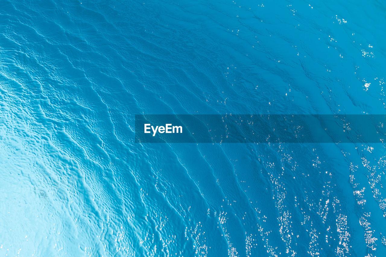 View of surface of turquoise water in swimming pool, sea or ocean, summer background. gradient 