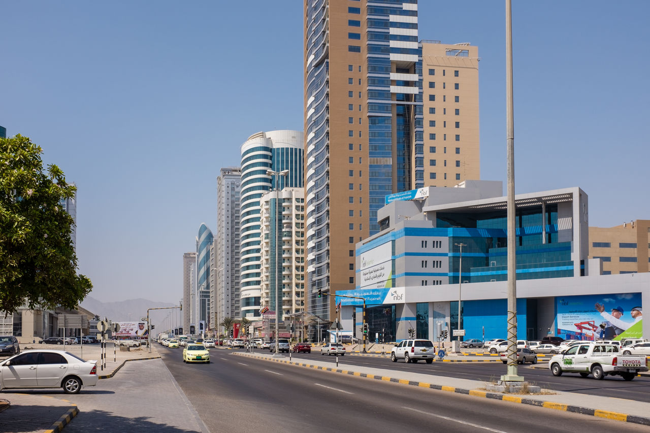 CITY STREET AND MODERN BUILDINGS AGAINST BLUE SKY