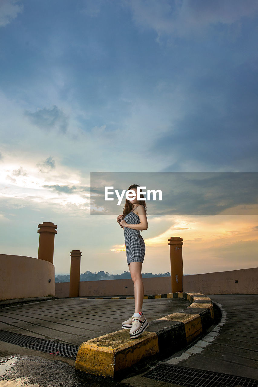 WOMAN STANDING AGAINST SKY