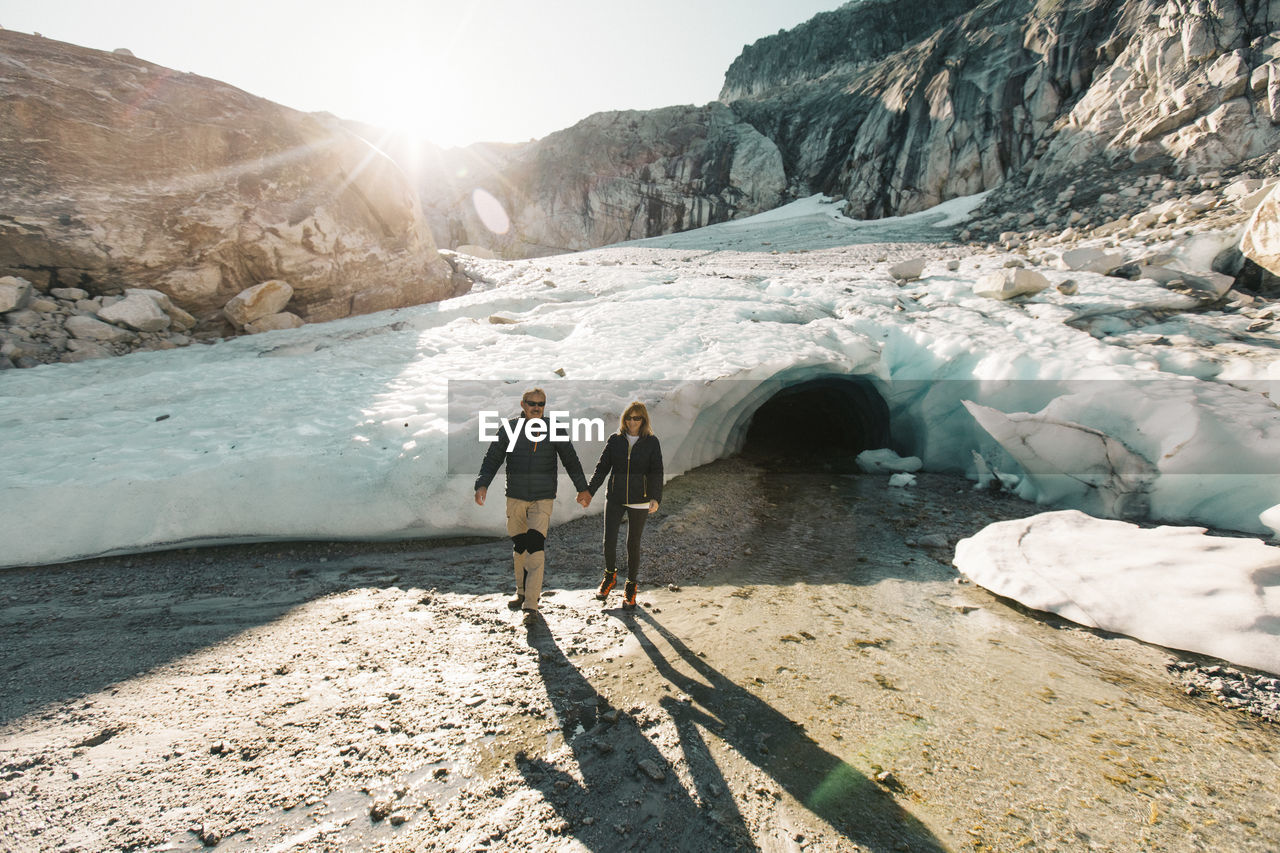 Retired couple enjoying a day exploring a glacial ice cave.