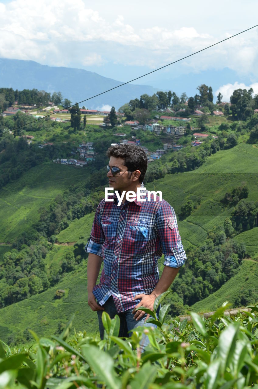 Young man wearing sunglasses standing on mountain