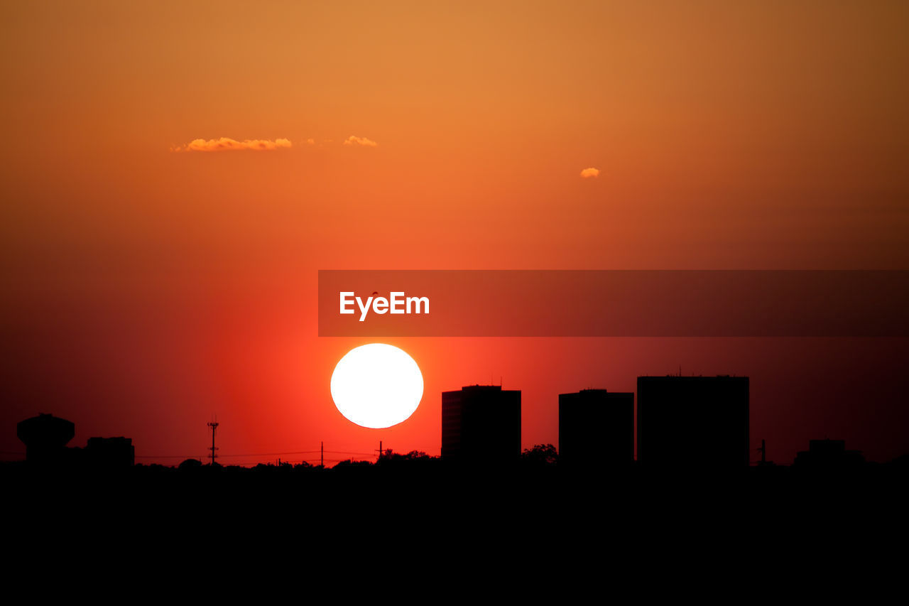 Silhouette of buildings against sky during sunset