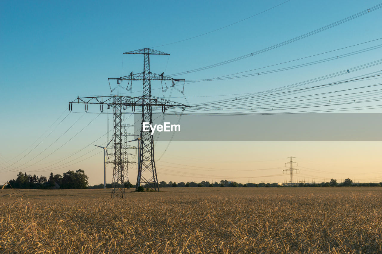 ELECTRICITY PYLON ON FARM AGAINST SKY