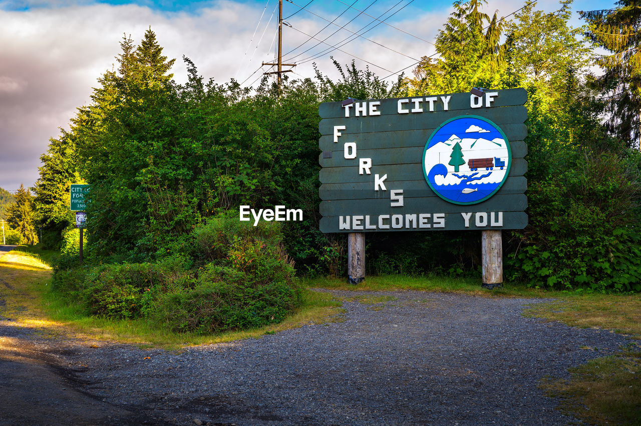 road, sign, communication, plant, tree, cloud, text, transportation, nature, sky, road sign, no people, symbol, western script, guidance, street, city, day, information sign, blue, outdoors