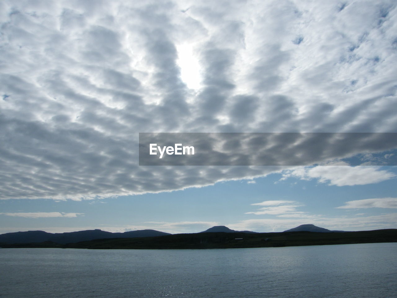 SCENIC VIEW OF LAKE BY MOUNTAIN AGAINST SKY