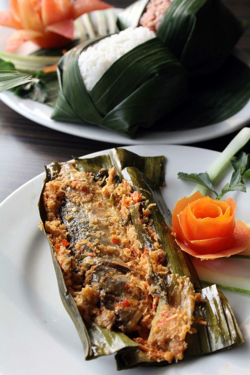 High angle view of cooked rice and fish served in plates on table