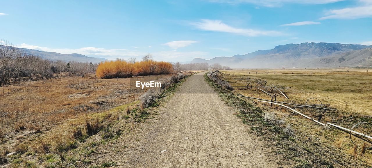 Dirt road along countryside landscape