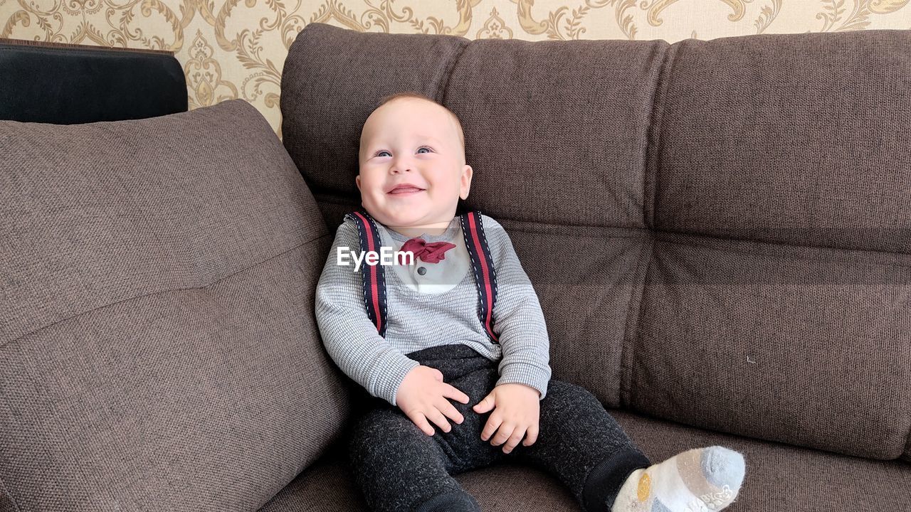 Cute girl sitting on sofa at home
