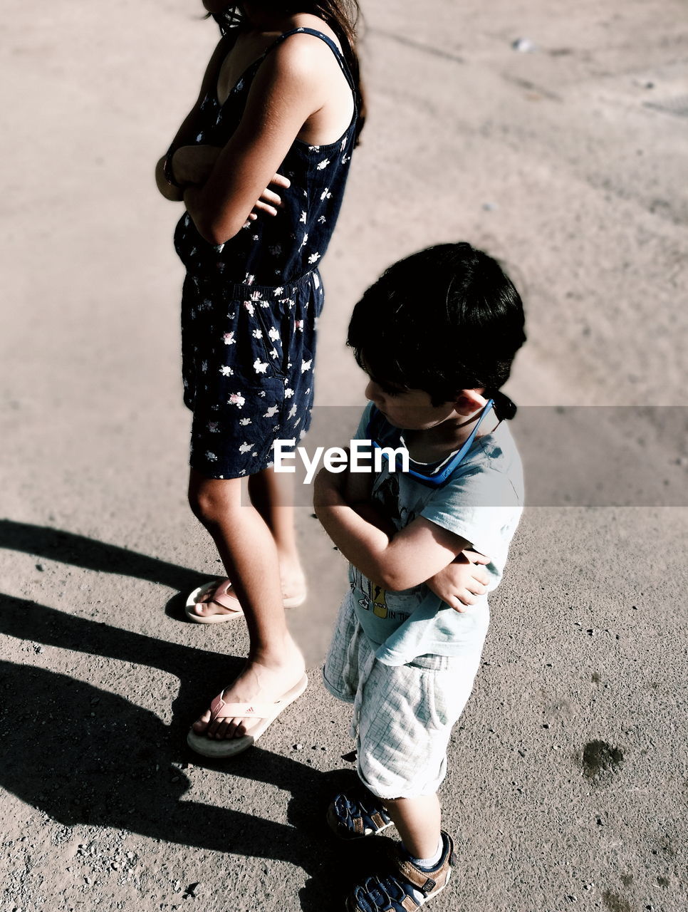 High angle view of siblings standing on rock