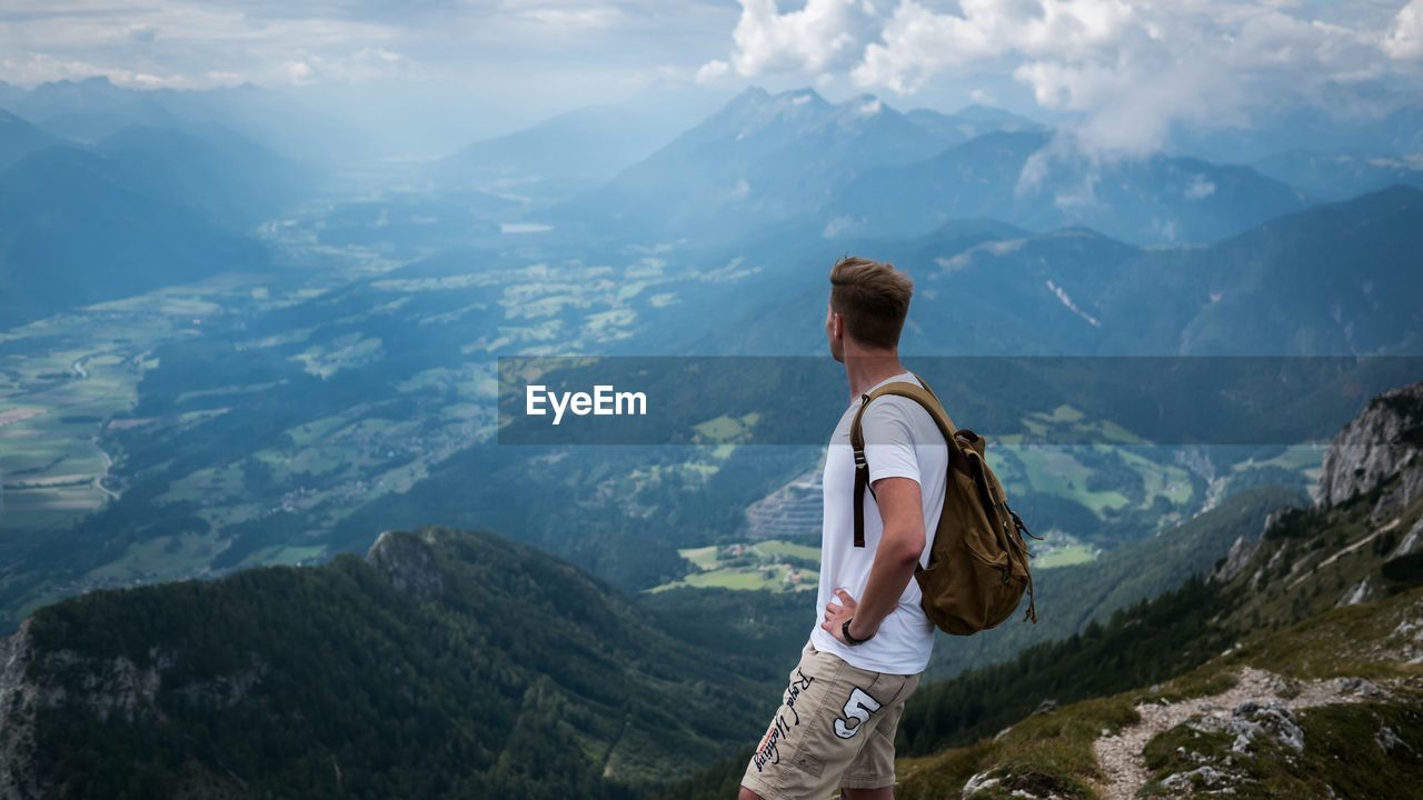 Side view of man looking at mountains