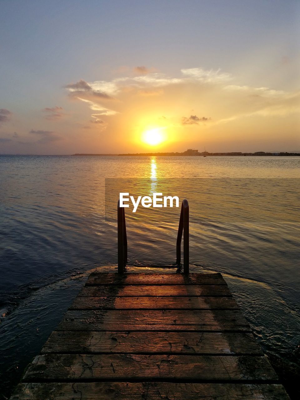 Pier over sea against sky during sunset
