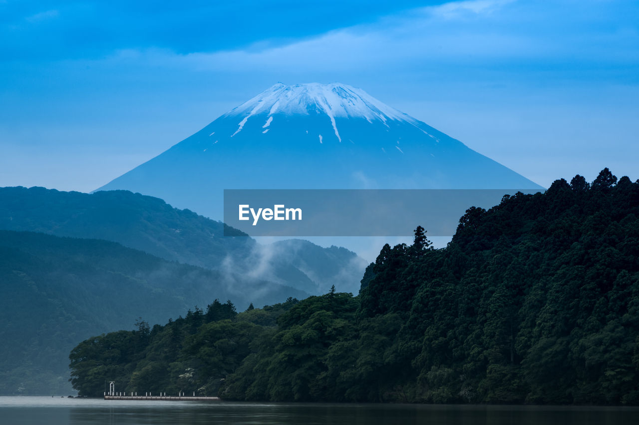 Scenic view of mountains against sky including mt. fuji with mist and lake  in foreground