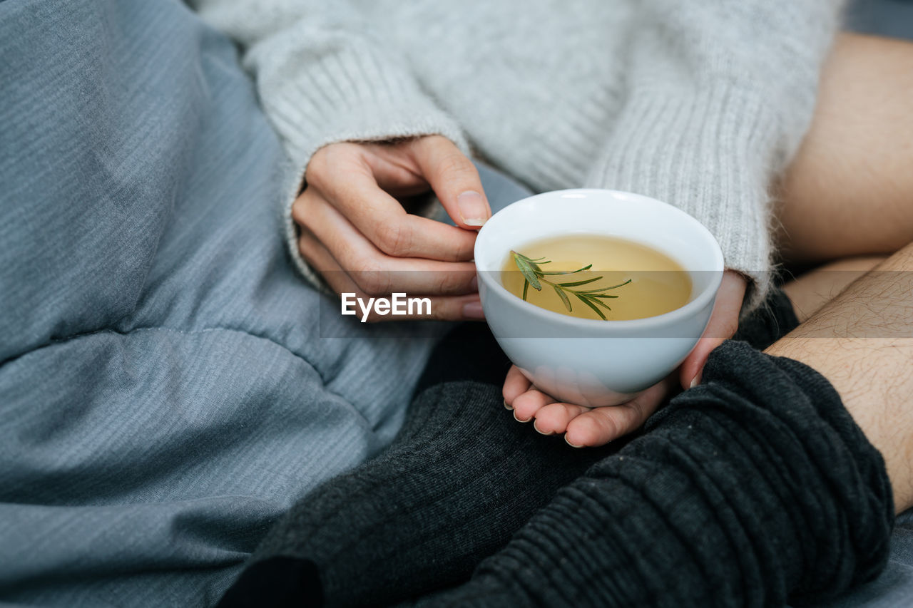 midsection of woman holding coffee cup