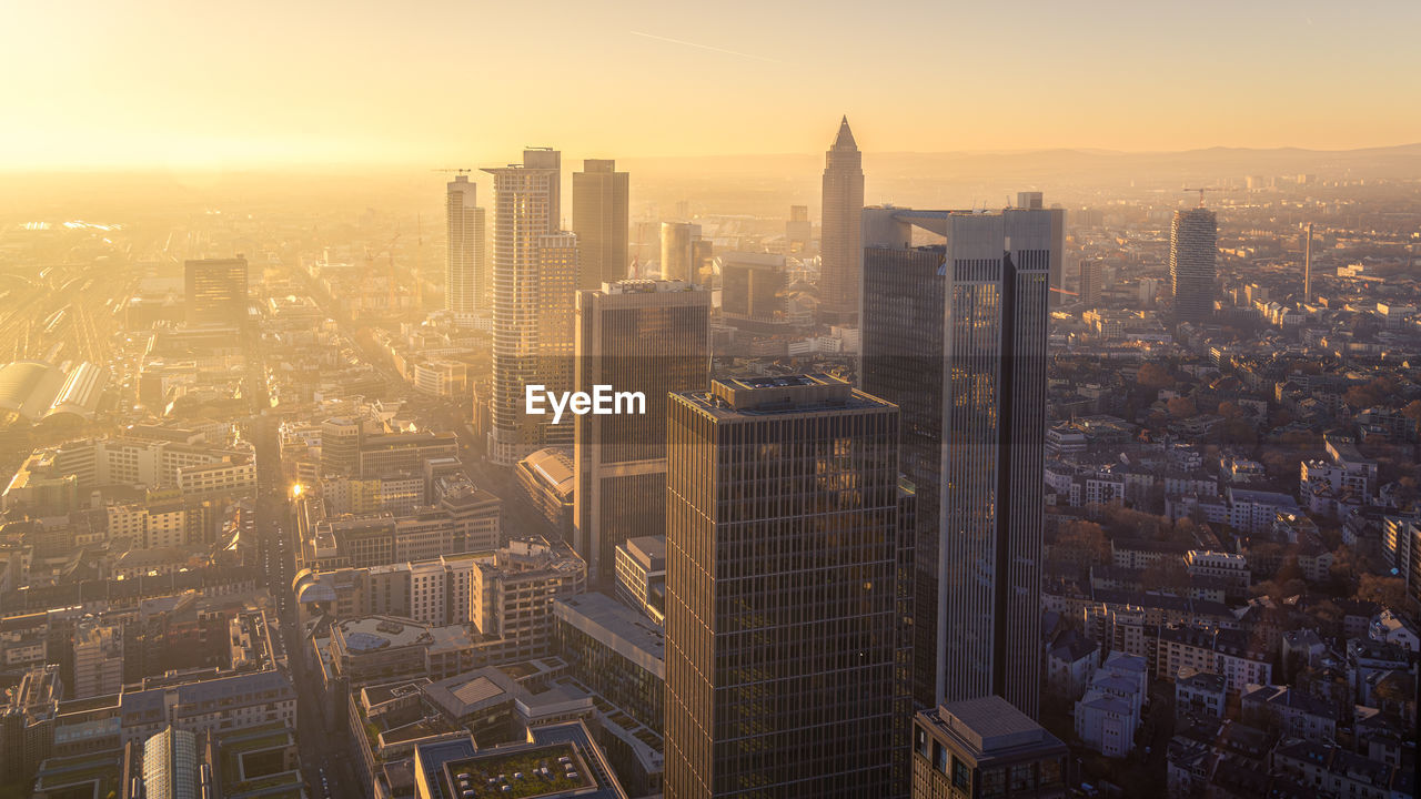 Aerial view of illuminated buildings in city during sunset