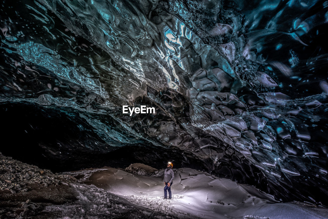 High angle view of man standing in frozen cave