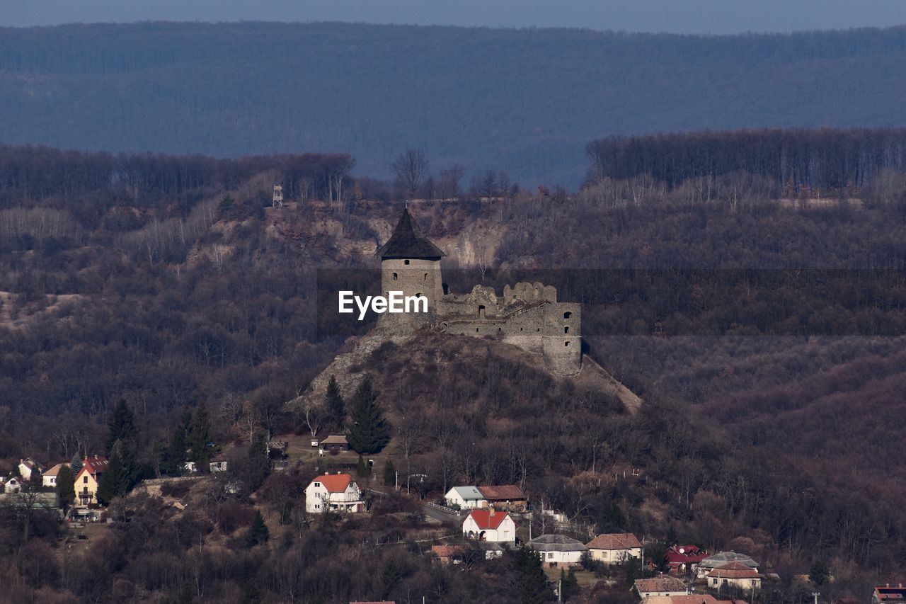 Castle on mountain against buildings