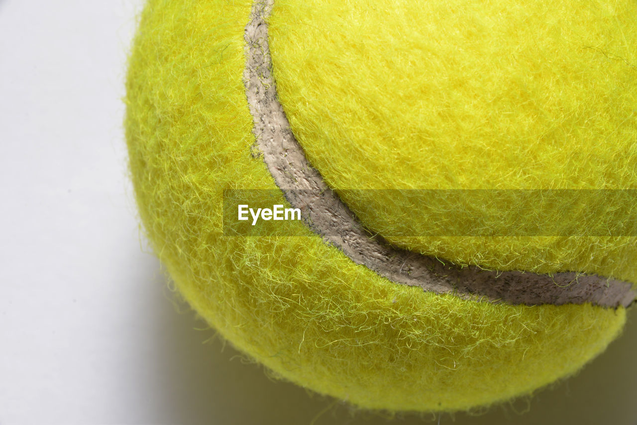 Close-up of tennis ball over white background