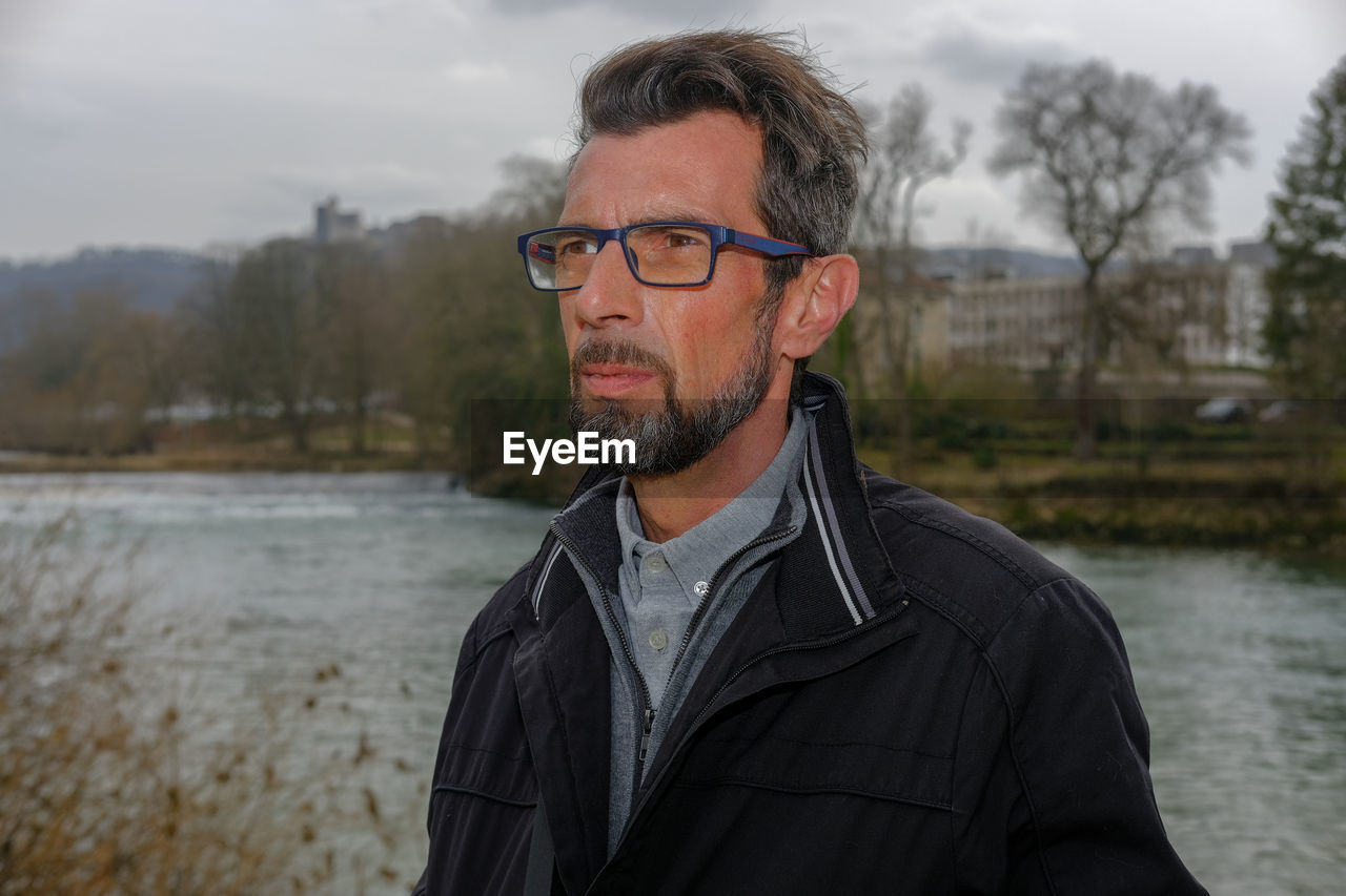 Portrait of man standing against water