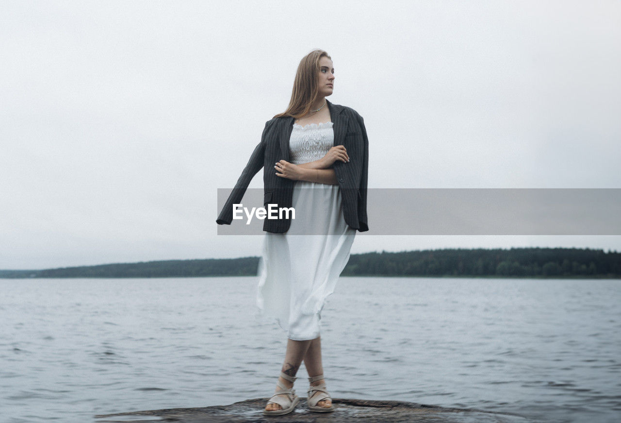 full length of young woman standing in lake