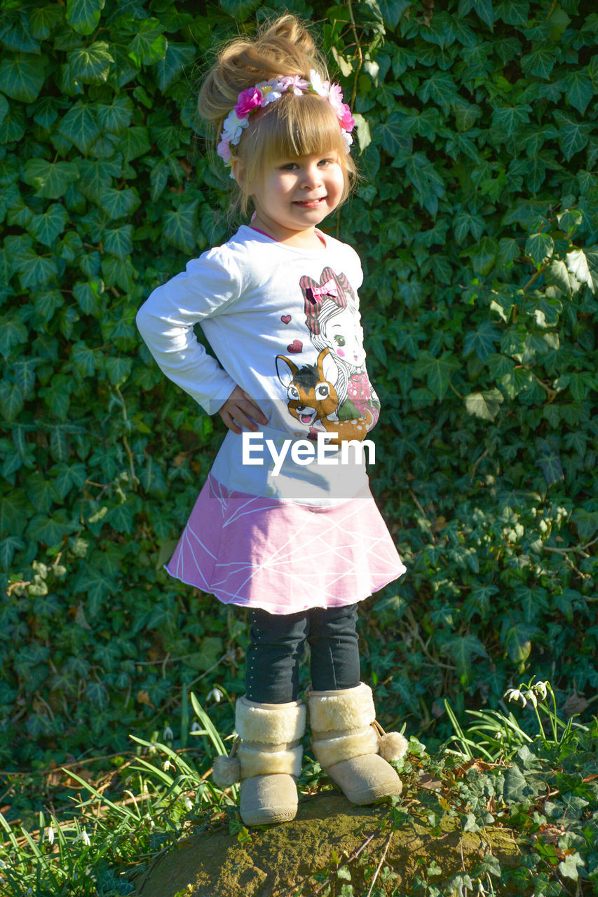Portrait of cute girl standing against plants
