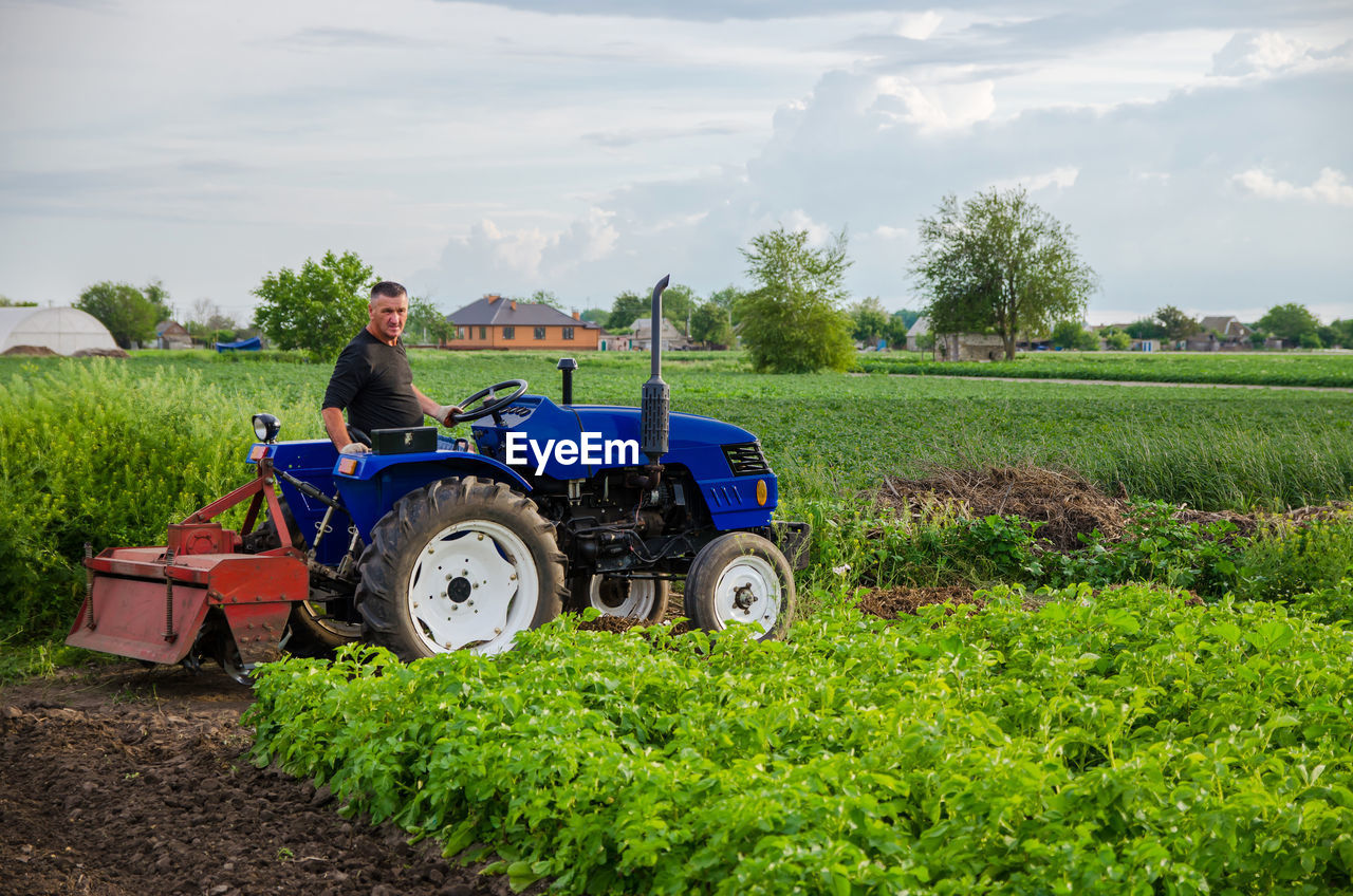 A farmer on a tractor works in the field. seasonal worker. recruiting and hiring employees 