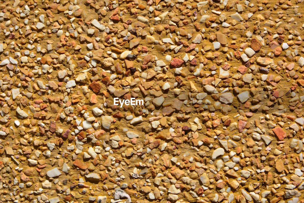 FULL FRAME SHOT OF PEBBLES ON WHITE SURFACE