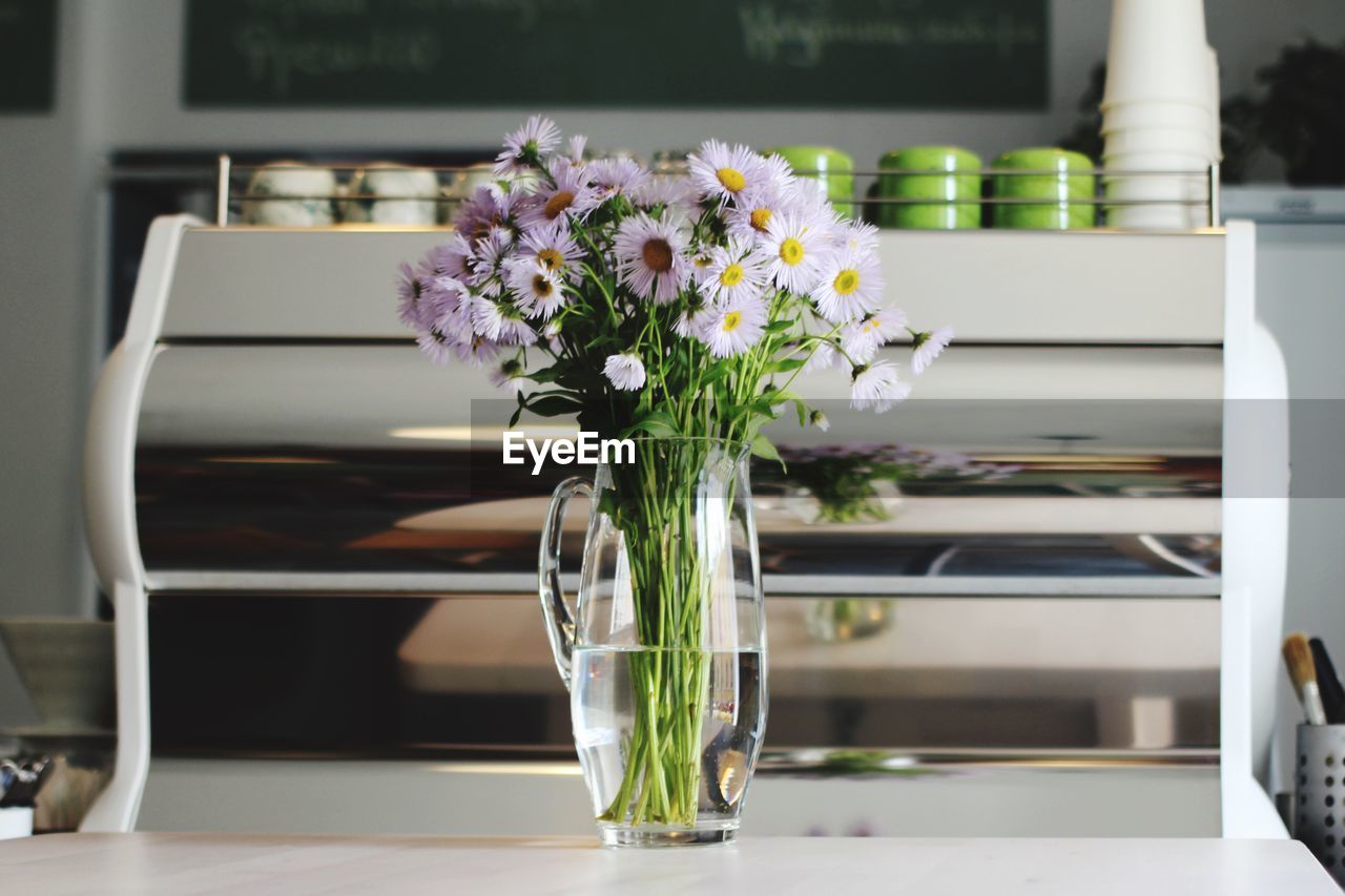 FLOWERS IN VASE ON TABLE