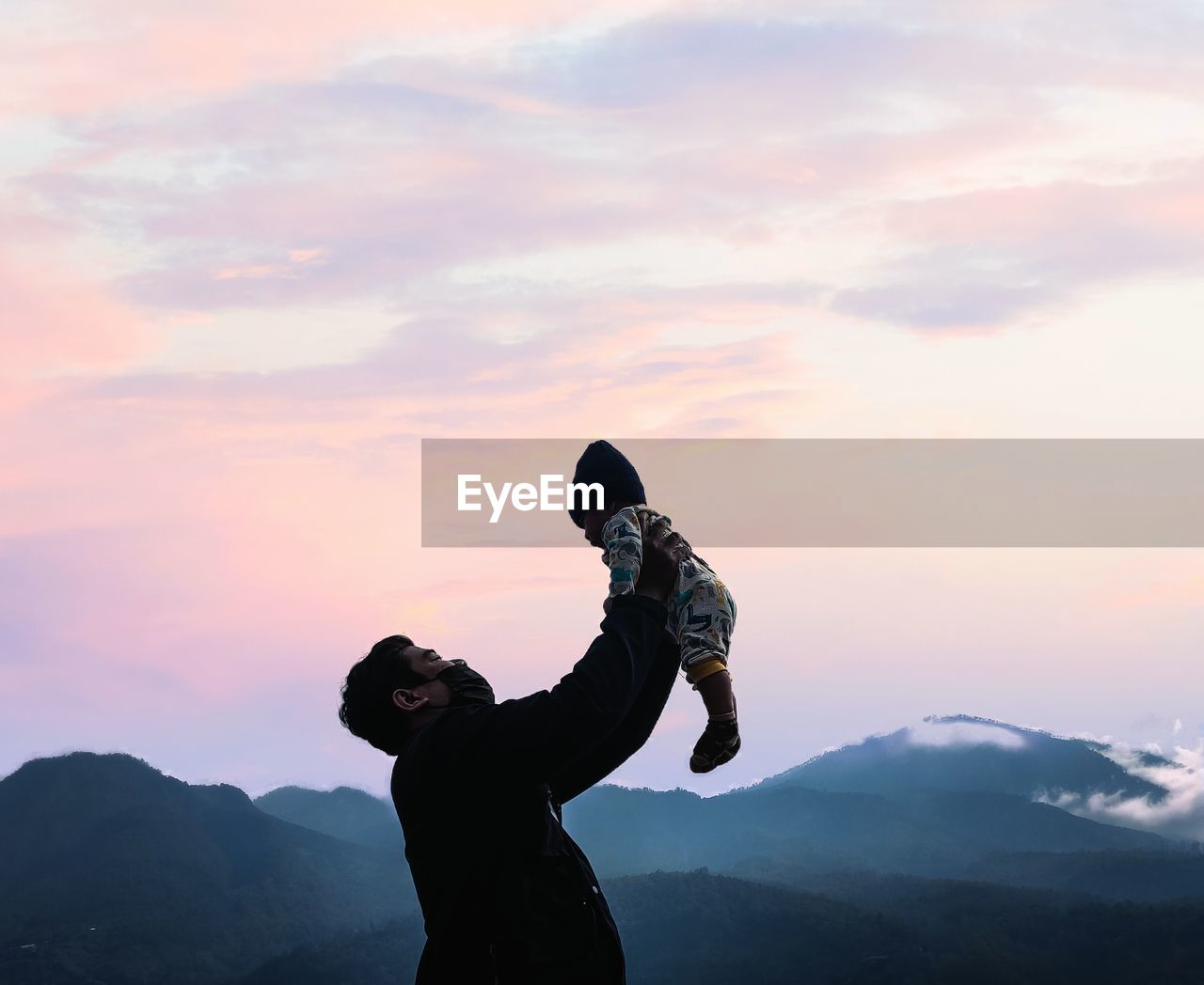 side view of silhouette woman standing on mountain against sky during sunset