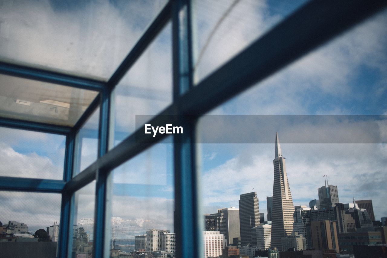 Transamerica pyramid seen through glass window in city