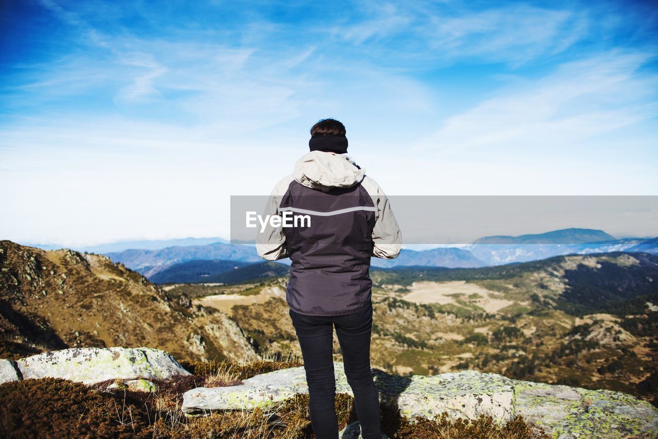 Rear view of woman standing against mountains