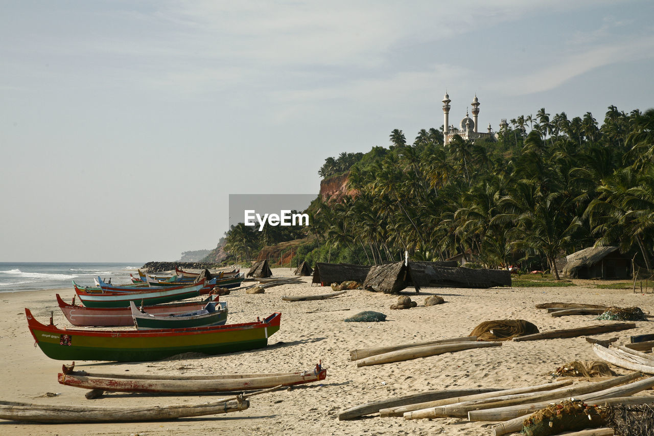 Boats moored on beach against sky