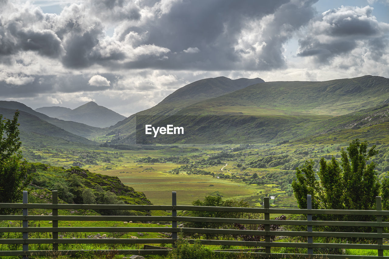 View from behind wooden fence on beautiful molls gap with owenreagh river, ring of kerry, ireland