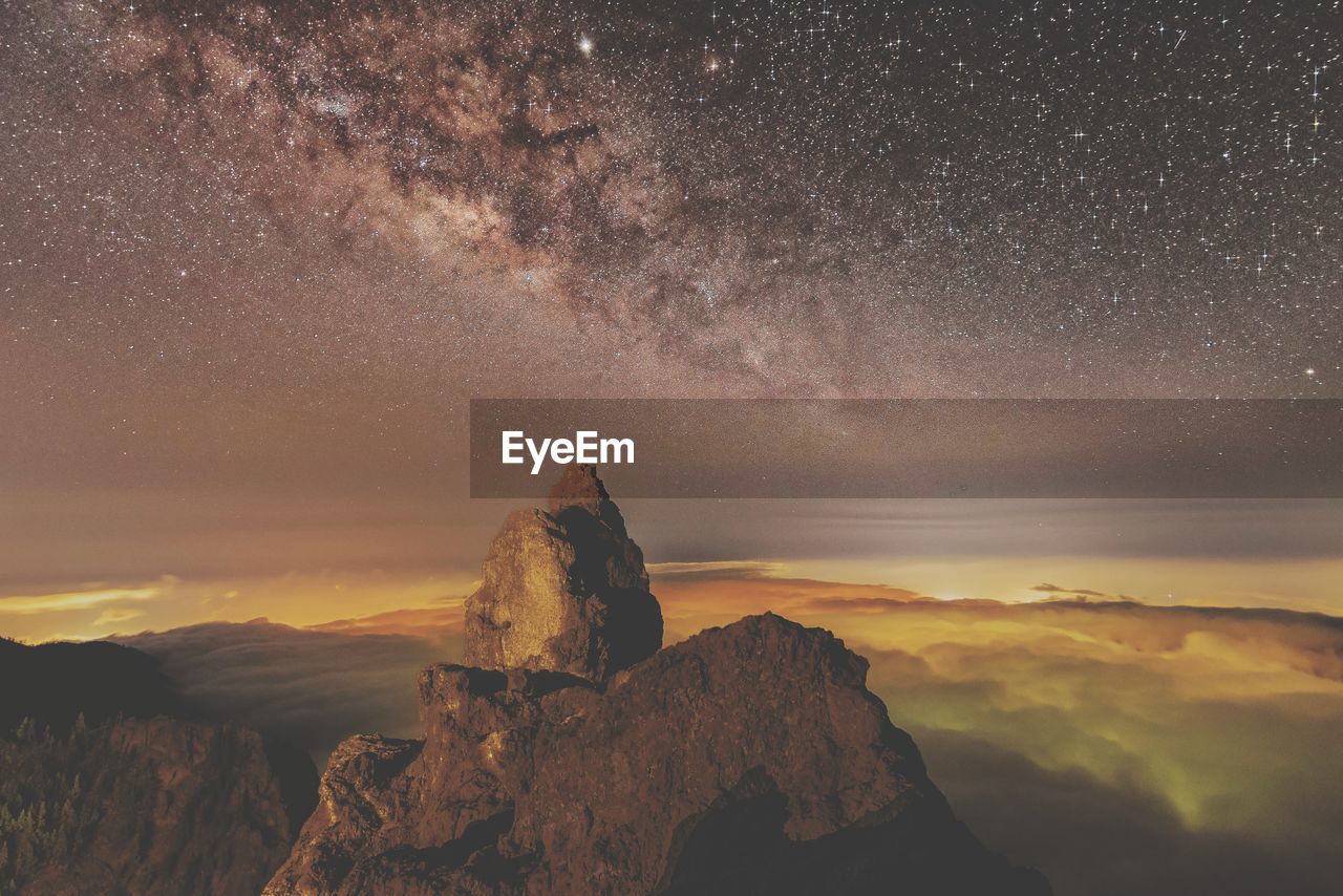 Scenic view of rock against sky at night