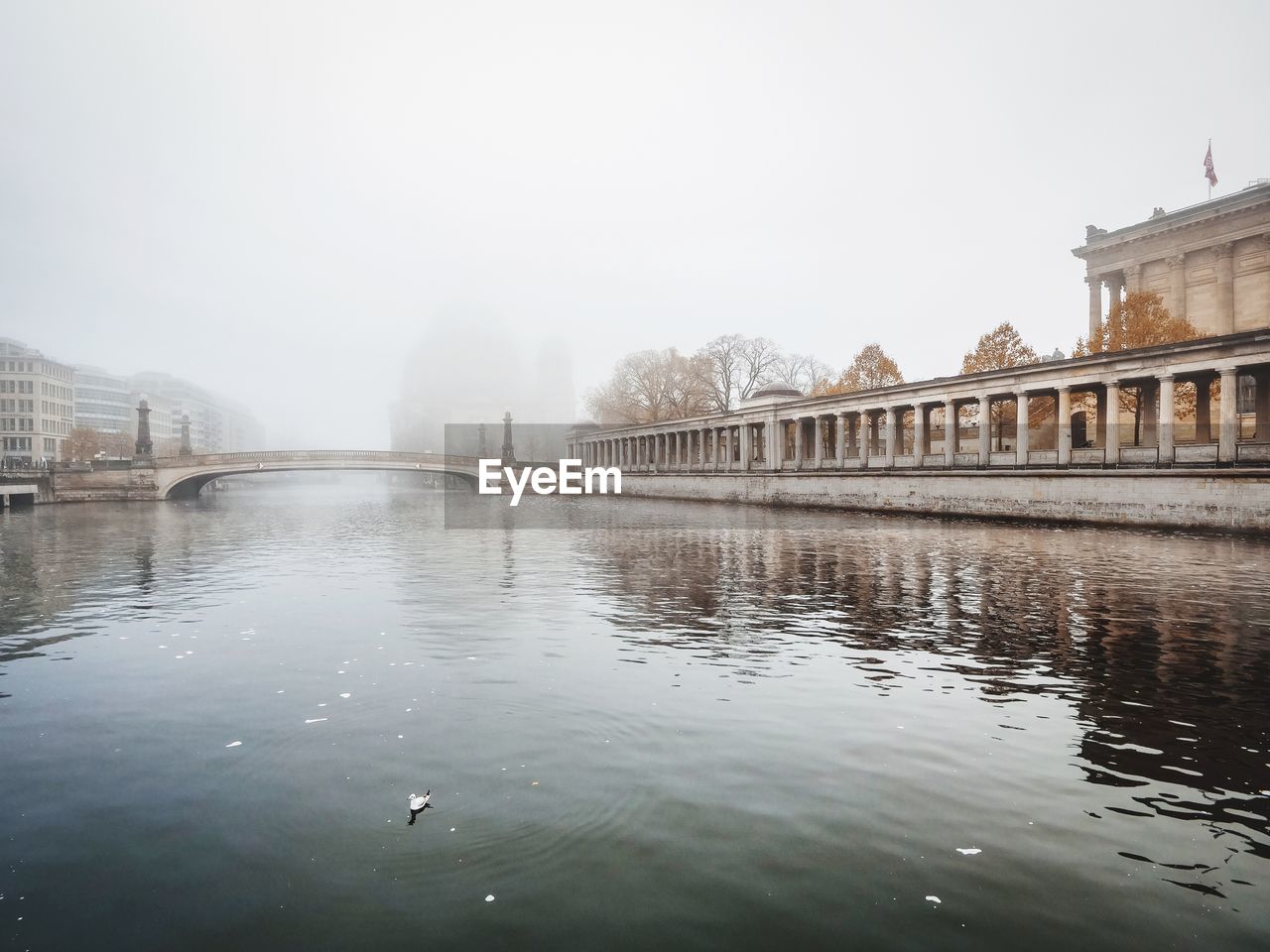 BRIDGE OVER RIVER IN FOGGY WEATHER