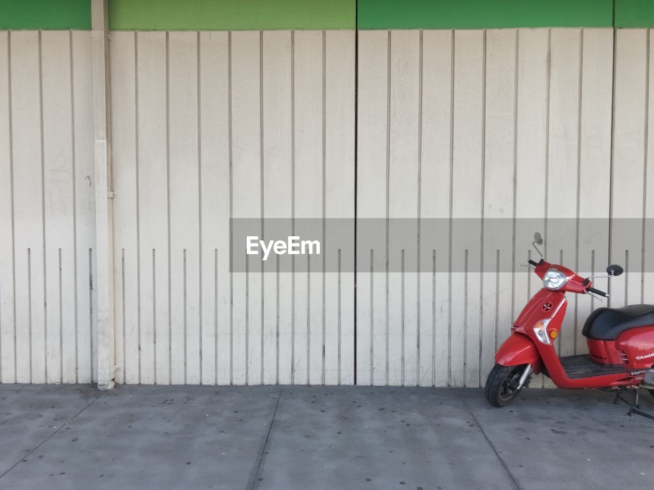Motor scooter parked by wall