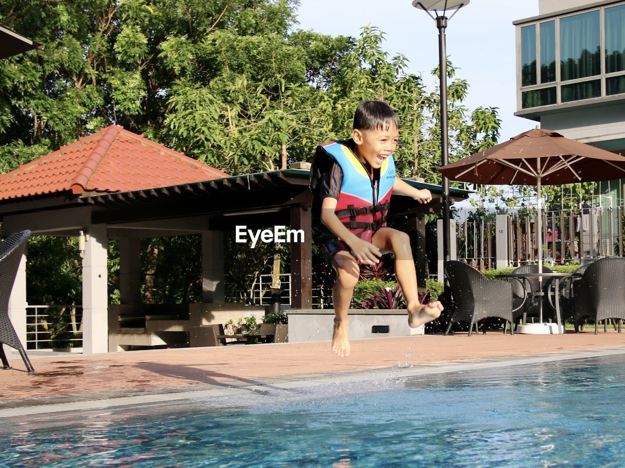 Full length of boy jumping in swimming pool