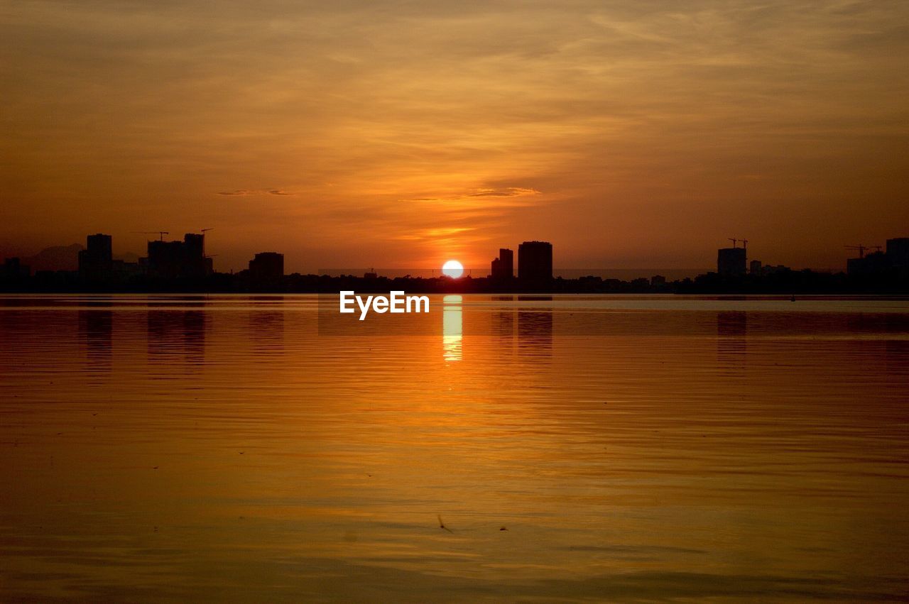 Scenic view of river against sky during sunset