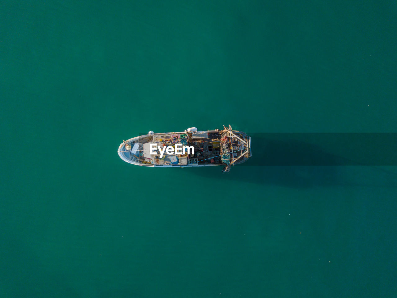 HIGH ANGLE VIEW OF BOAT IN SEA AGAINST GREEN BACKGROUND