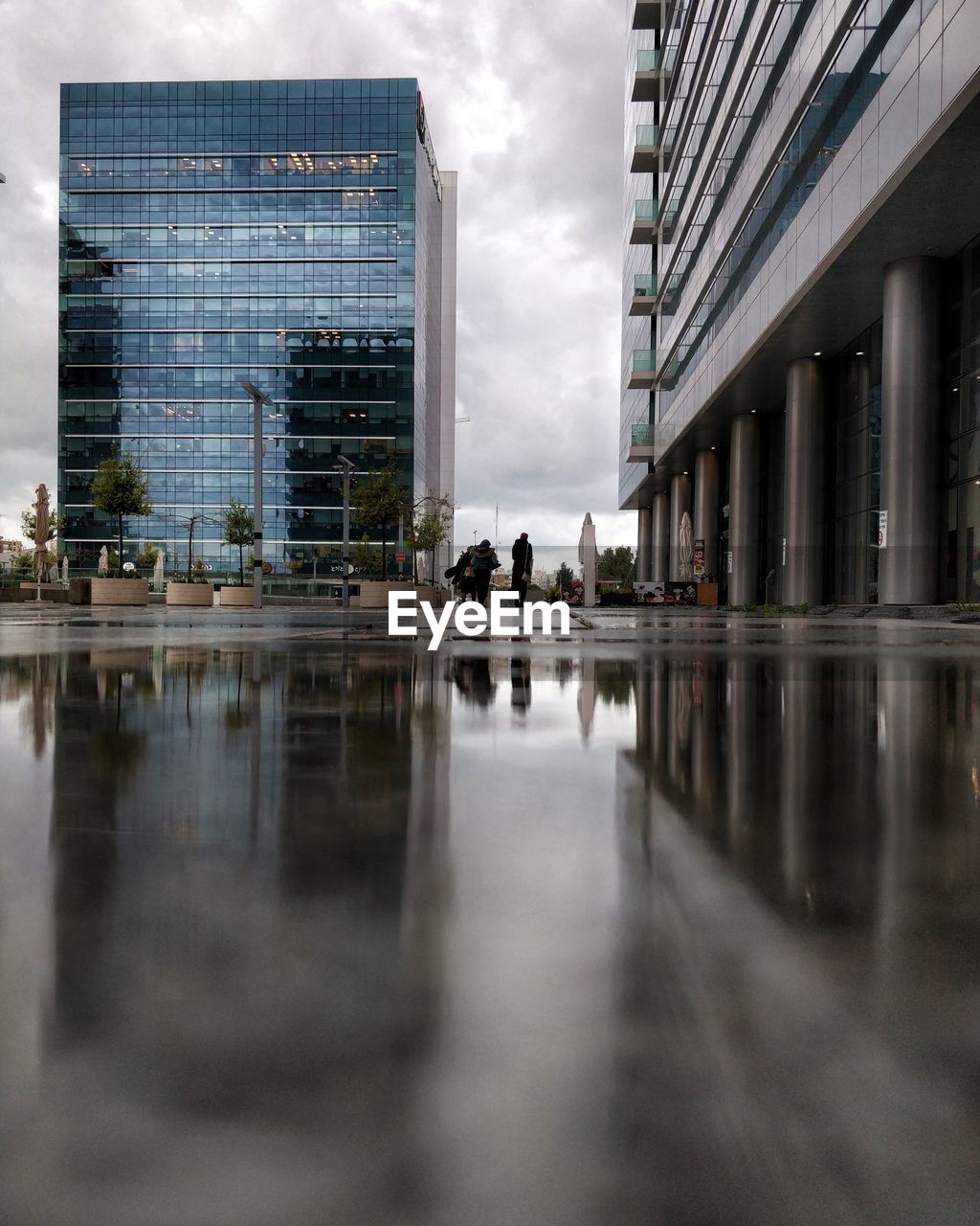 Reflection of buildings in city against sky