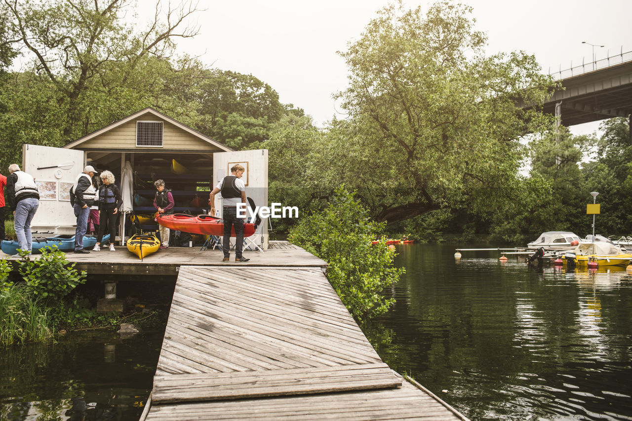 Senior men and women on jetty over sea during kayaking course