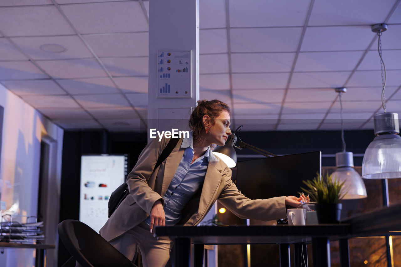 portrait of young woman using mobile phone while sitting in office