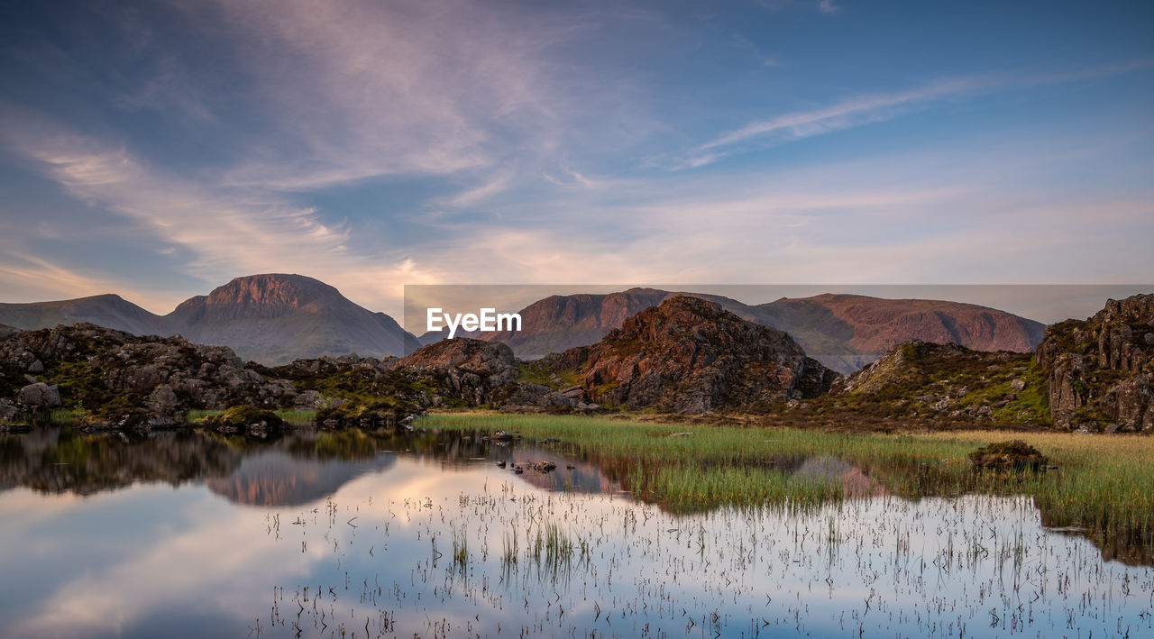 SCENIC VIEW OF LAKE BY MOUNTAIN AGAINST SKY