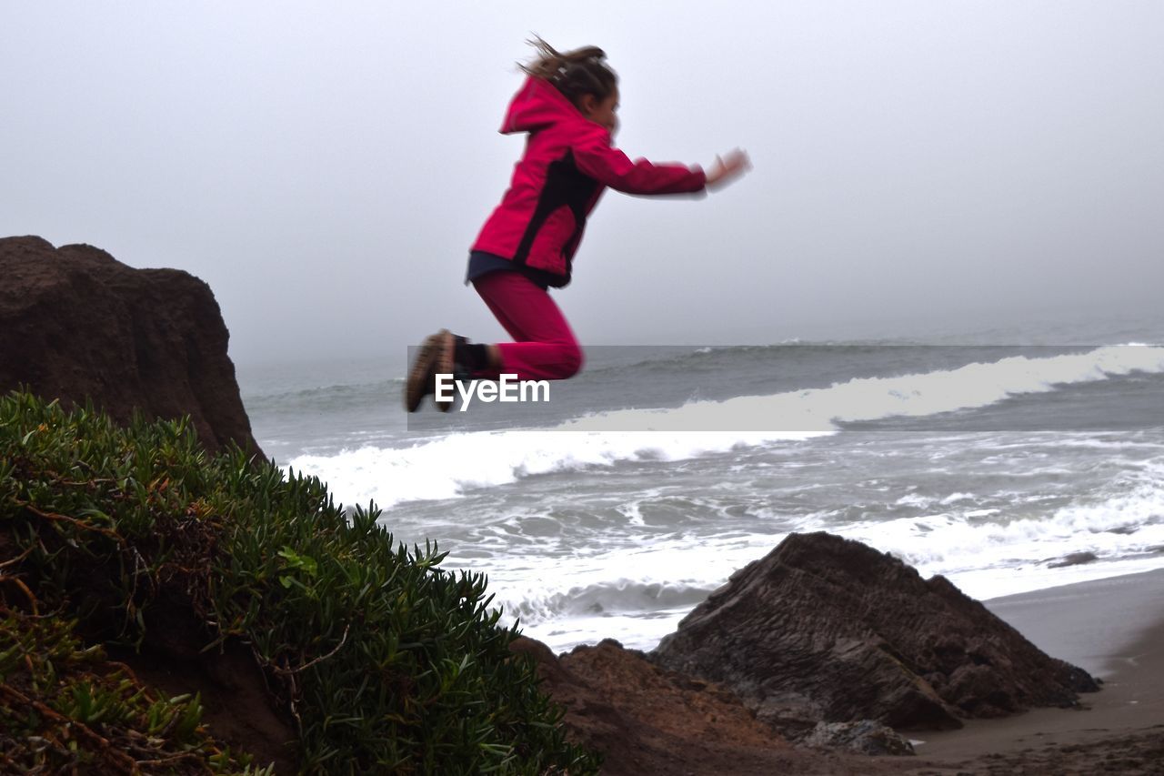 WOMAN STANDING ON BEACH