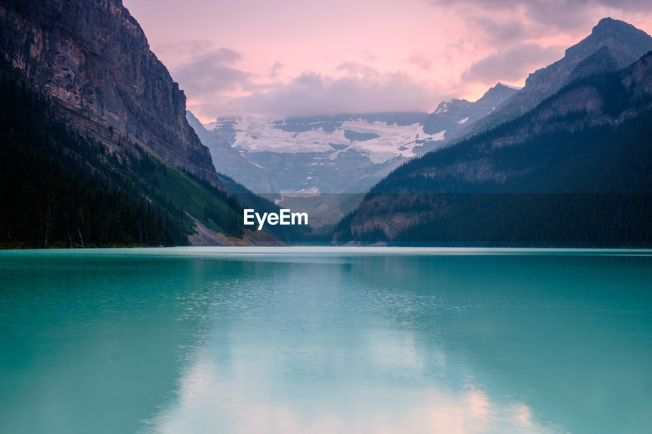 Scenic view of lake and mountains against sky during sunset