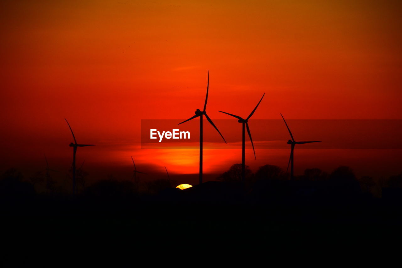 Scenic view of sunset and windmills
