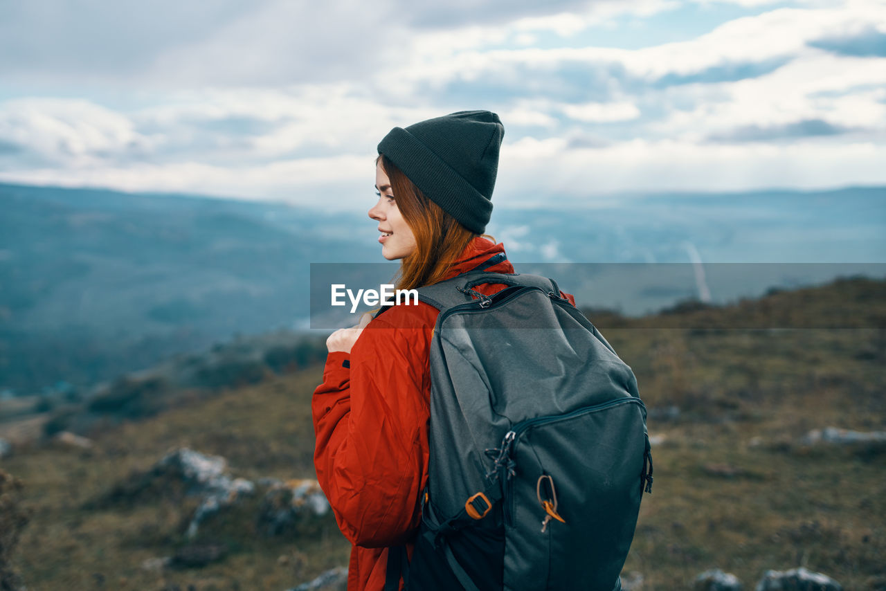 MIDSECTION OF MAN STANDING AGAINST MOUNTAIN