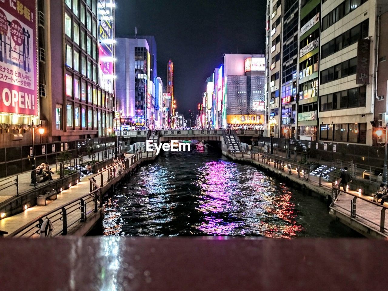 Canal amidst buildings at dotonbori during night