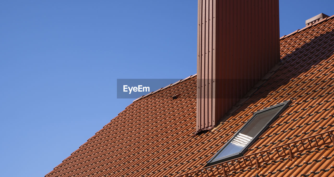 LOW ANGLE VIEW OF ROOF AND BUILDING AGAINST CLEAR BLUE SKY