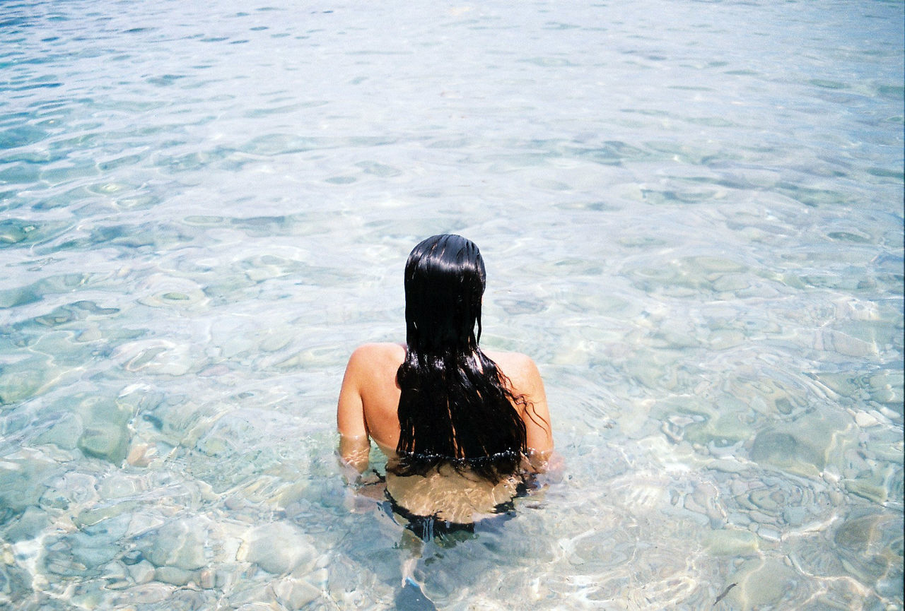 Rear view of woman swimming in lake